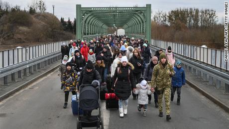 Ukrainian refugees cross a bridge in Ukraine near the Polish border on March 6, 2022.