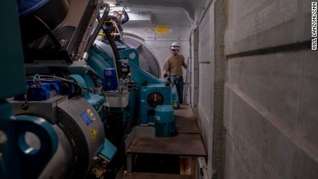 Blake Panek, senior wind technician, performs a routine inspection inside one of the wind turbines at the Traverse wind farm. To his left is Matt Miller, environmental coordinator principal at Traverse.