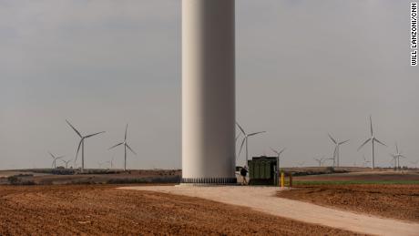 A worker walks along the base of a wind turbine at the Traverse wind farm.