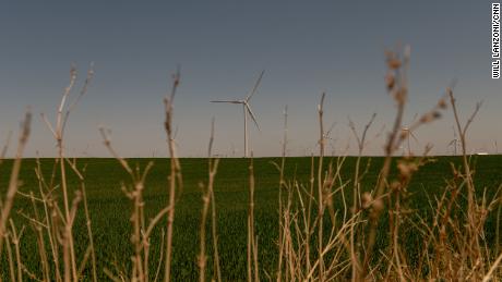 A wind turbine spins over a wheat field in Weatherford.