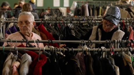 Evacuees look through racks of donated clothing at the  Kryvyi Rih hall. 