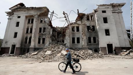 A man walks past the shell of Mariupol&#39;s Drama Theater on April 25.