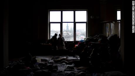 Families, their belongings stacked in piles around them, look out over the entrance to Lviv train station. Outside, lines of buses take refugees to the Polish border.