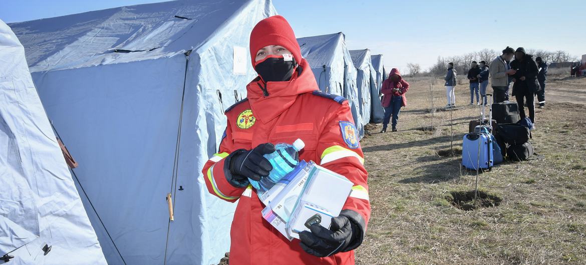 A health worker carries COVID-19 medical supplies in a camp for Ukrainian refugees, at the border with Moldova.