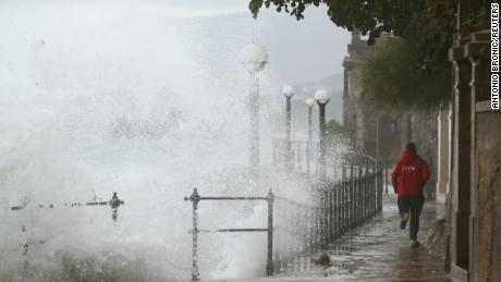 A man runs away from waves in Volosko, Croatia, on October 29, 2018.