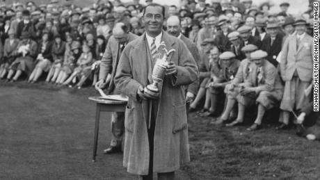 Hagen, holding the Claret Jug, on the 1st tee during an exhibition match with Joe Kirkwood at Llanwern, South Wales in 1937. 