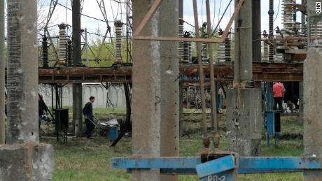 Railway workers clear debris from the power station in Lviv.