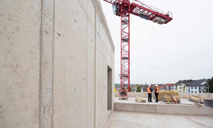 Two men wearing safety vests talking on construction site