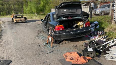 Children&#39;s clothes and toys litter the area around the vehicles.