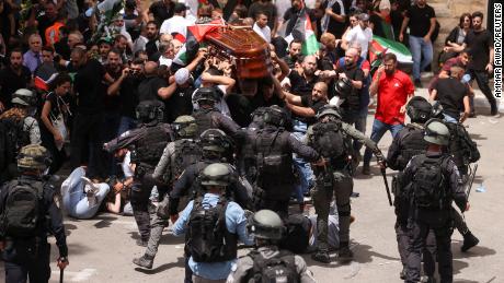 Israeli police approach pallbearers carrying the body of Abu Akleh with batons at her funeral on Friday.
