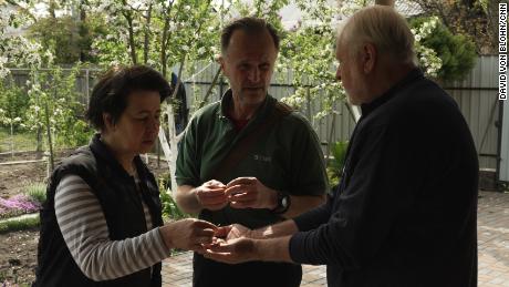 Anzhelika Kolomiec and Ihor Novohatniy show their friend Olegh Bondarenko the metal darts they found scattered around their property.