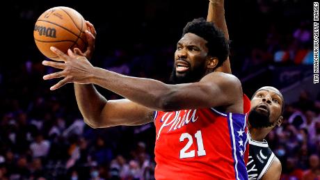 Embiid passes under pressure from Kevin Durant of the Brooklyn Nets.