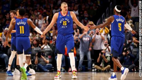 Jokic high-fives his teammates after a basket against the San Antonio Spurs on October 22, 2021.