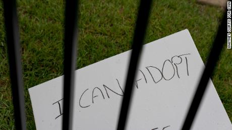 A handmade sign lies on the ground outside the fence surrounding the Fairview Heights clinic.