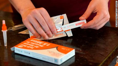 A  worker prepares one of the new government-issued Covid-19 Antigen Rapid test kits she received to take a self-test while at home on February 8 in Provo, Utah. 