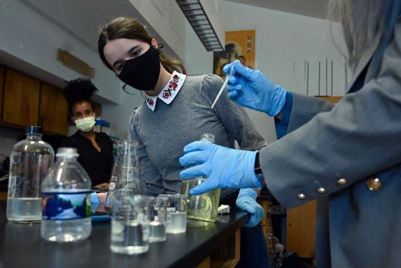 Rebecca Bushmay (R), assisted by 18-year-old student Erin Osterman, demonstrates the use of the lead water filter