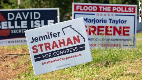 Campaign signs for Strahan, center, and Greene, right, are seen just outside of Rome in Silver Creek, Georgia, on May 12, 2022.