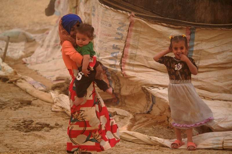 Beduin shepherds shelter from a sandstorm in tents alongside their flock in Iraq's al-Henniyah area outside of Najaf, on May 23,