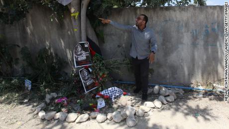 Palestinian journalist Mujahid al-Saadi, who was with Abu Akleh when she was killed, points to bullet marks on the tree in Jenin where she died.