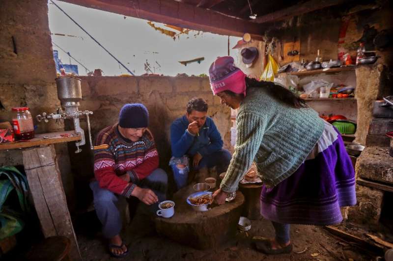 Saul Luciano Lliuya (left), his son Brandon (centre) and wife Lidia live in a modest house with a tree trunk for a dining table