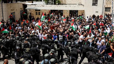 Family and friends carry the coffin of Abu Akleh, as Israeli security forces stand guard during her funeral in Jerusalem on May 13.