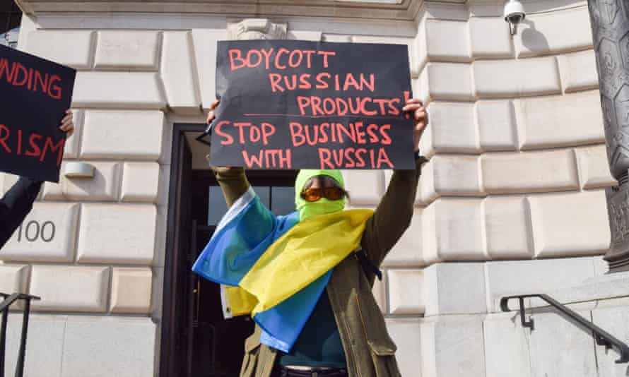 A protester outside the Unilever headquarters in Victoria Embankment, London, holds a placard calling for a boycott of Russian products.