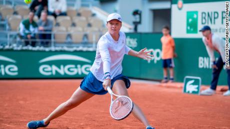 Swiatek plays a backhand against Zheng.