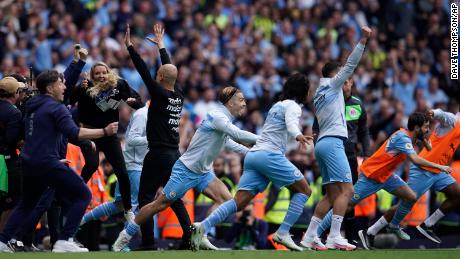 Manchester City&#39;s manager Pep Guardiola and his team celebrate after winning the English Premier League.