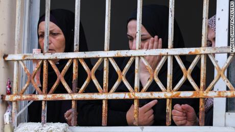 Mourners attend Amjad al-Fayed&#39;s funeral from a window in Jenin.