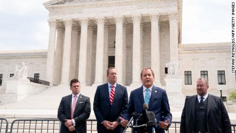 Texas Attorney General Ken Paxton (2R) and Missouri Attorney General Eric Schmitt (2L) speak to reporters in front of the US Supreme Court in Washington, DC, on April 26, 2022. 