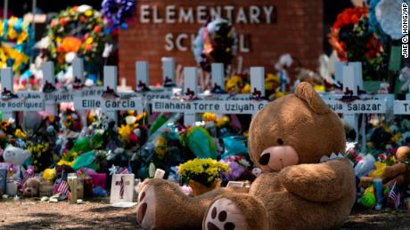 A large teddy bear is placed at a memorial in front of crosses bearing the names of the victims killed in this week&#39;s school shooting in Uvalde, Texas, on Saturday.  