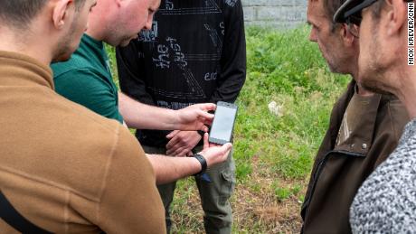 Agents from Ukraine&#39;s security service search the phone of a suspect believed to have sent information to Russian forces.