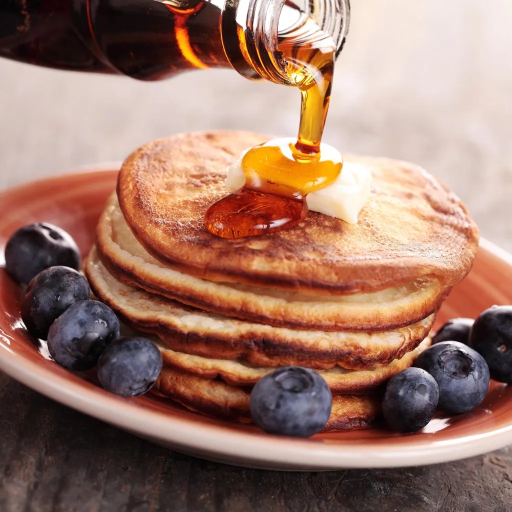 Pouring Maple Syrup on Pancakes