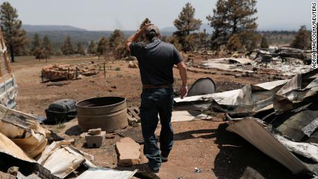 Michael Salazar walks through his property that was burned during the Hermits Peak and Calf Canyon fires in Tierra Monte, New Mexico.