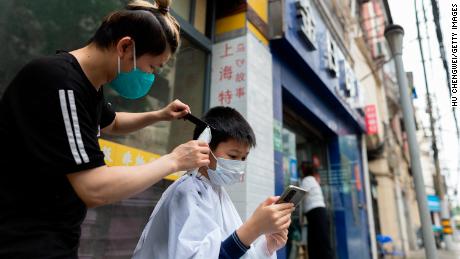 A barber cuts the hair of a boy in a Shanghai street on Wednesday.