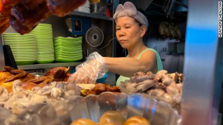 Chicken-rice seller Madam Tong prepares a dish for a customer.