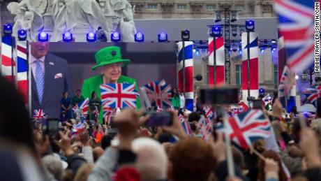 A screen in front of Buckingham Palace shows the Queen&#39;s balcony appearance on Sunday. 