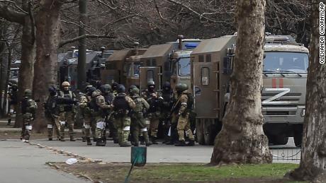 Russian army soldiers stand next to their trucks during a rally against Russian occupation in Svobody (Freedom) Square in Kherson on March 7, 2022.