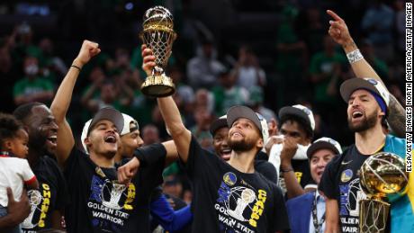 Curry raises the Bill Russell NBA Finals MVP Award after defeating the Celtics in Game 6 of the 2022 NBA Finals.