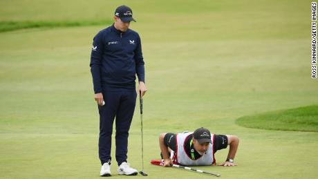  Fitzpatrick and caddie Billy Foster line up a putt on the 15th green.