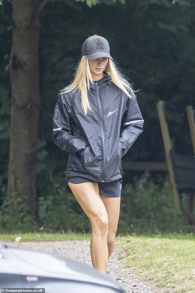 Leggy display: Amelia complemented him in a casual outfit, made up of a black waterproof jacket and matching shorts that showed off her tanned legs