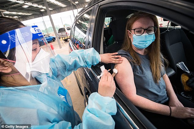 The shortages are mainly being driven by Covid and Influenza cases, which have exacerbated pre-existing roster issues. Pictured: A woman receives a Covid vaccine in Melbourne in August