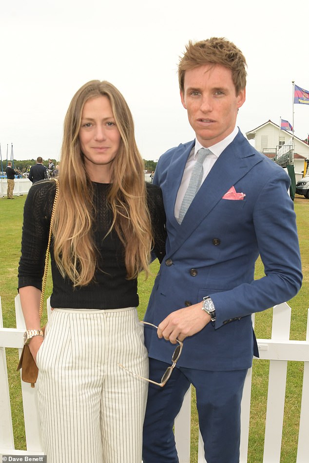 Looking good: The Fantastic Beasts star teamed the suit with a crisp white shirt and a grey tie as he beamed for photos