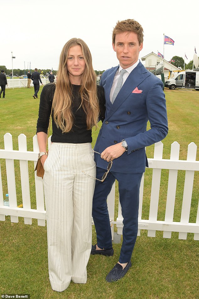 Loved up: Hannah looked effortlessly chic in a pair of white wide leg striped trousers