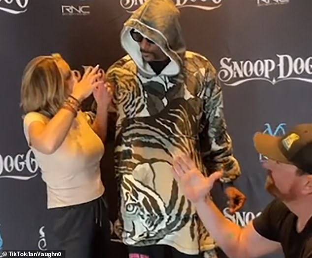 Excited: The female fan seemed more interested in Snoop's reaction and completely missed the moment when her new fiancé tried to celebrate the engagement