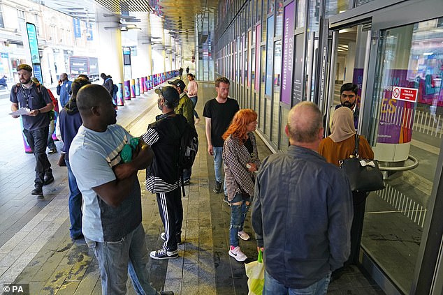 Passengers wait for the doors to open at 7am at Birmingham New Street station today