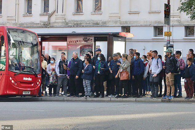 Commuters queue at a bus stop outside King's Cross in London this morning