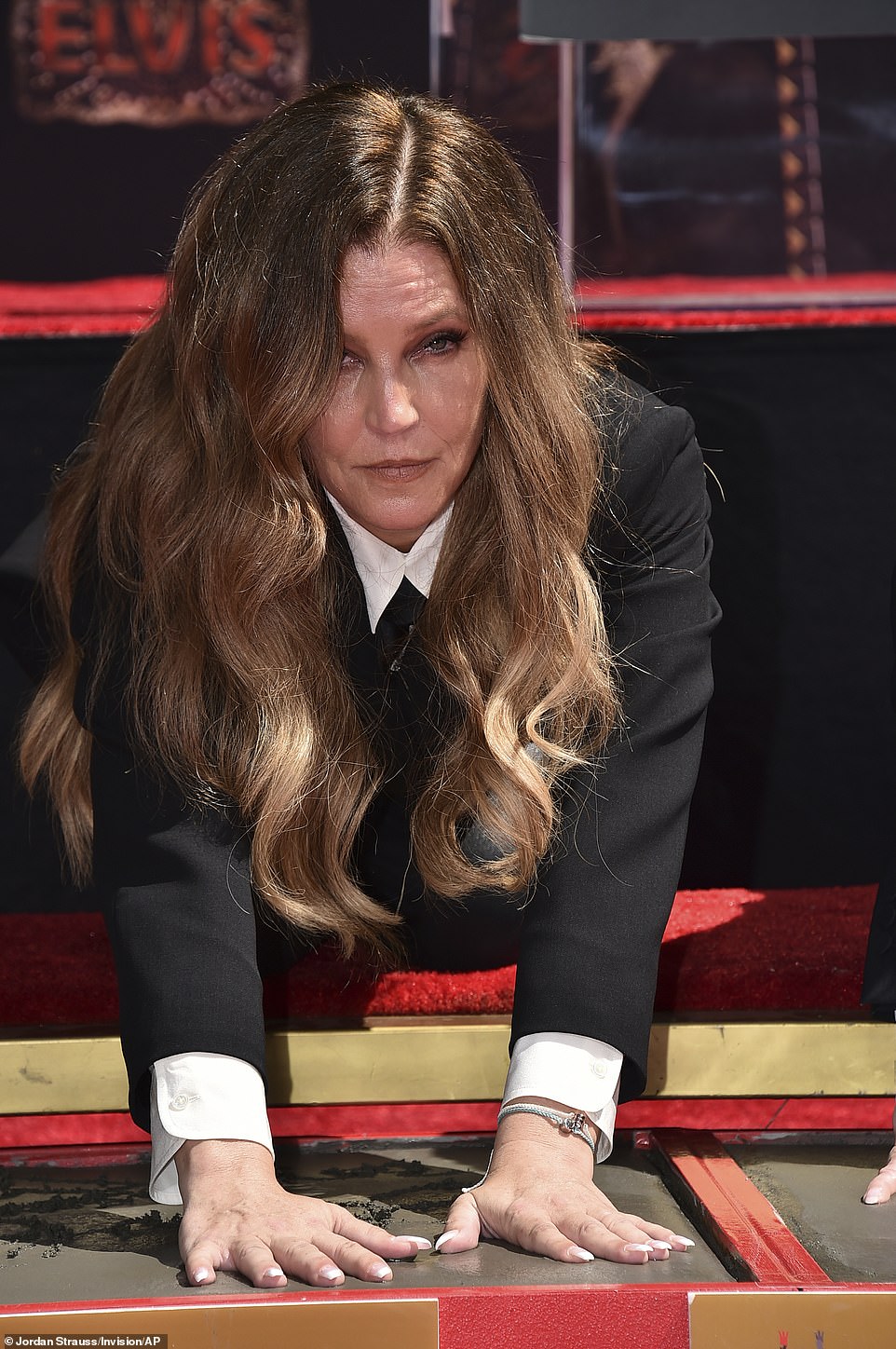 Star power: Meanwhile her daughter Lisa Marie wore a white shirt and black suit with a French manicure