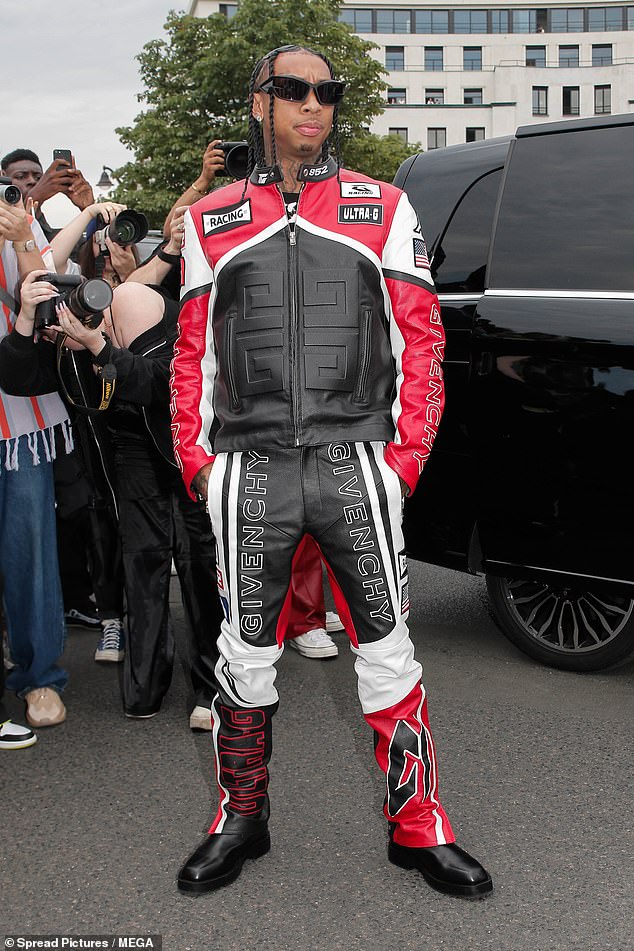 Cool: She was joined at the fashion show by Tyga, who looked effortlessly cool in a red, black and white Givenchy racing jacket