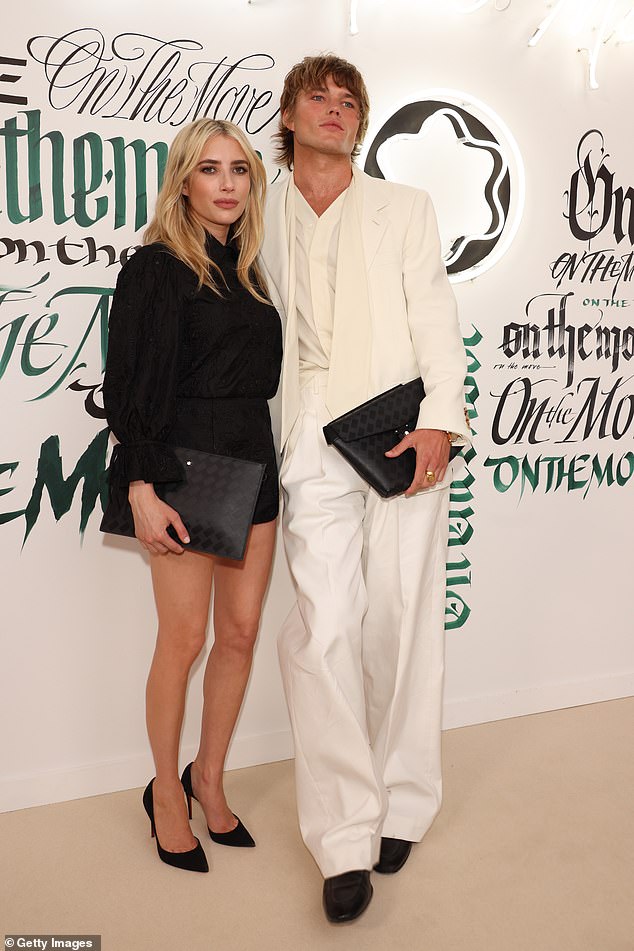 Film star Emma, 31, cut a trendy figure for the event where she donned a black playsuit with a high collar (pictured with Jordan Barrett)